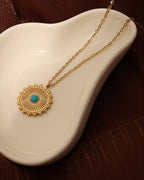 Detalle de collar Ojo del Alba con acabado dorado