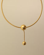 Detalle de collar Órbita Lariat con acabado dorado
