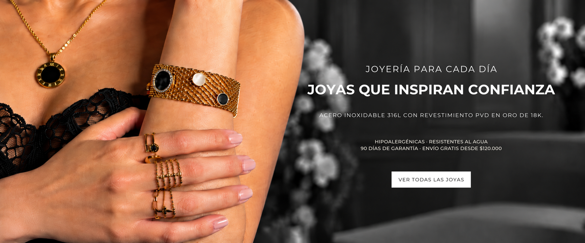 Modelo luciendo collar, pulsera y anillos dorados de Xihe By Dm, joyas en acero inoxidable 316L con revestimiento PVD en oro de 18K.